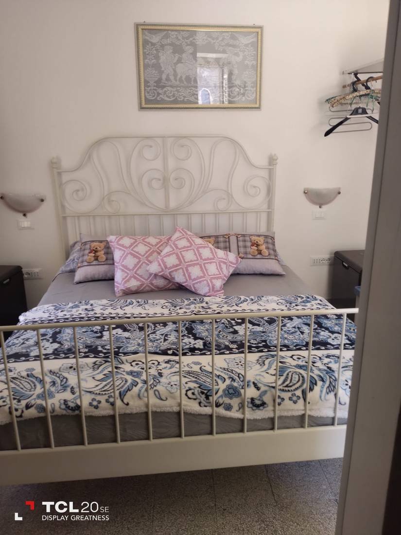 Camera matrimoniale con letto in ferro battuto bianco