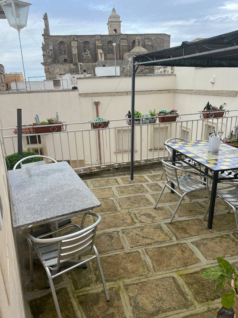 Terrazza esterna con tavolo da pranzo e vista sulla chiesa madre di Spongano