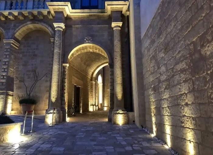 Portale d'ingresso illuminato di un palazzo storico nel Salento, di sera
